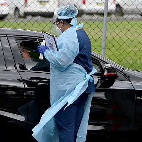 Healthcare workers administer COVID-19 tests at a drive through test centre in Liverpool, Sydney.