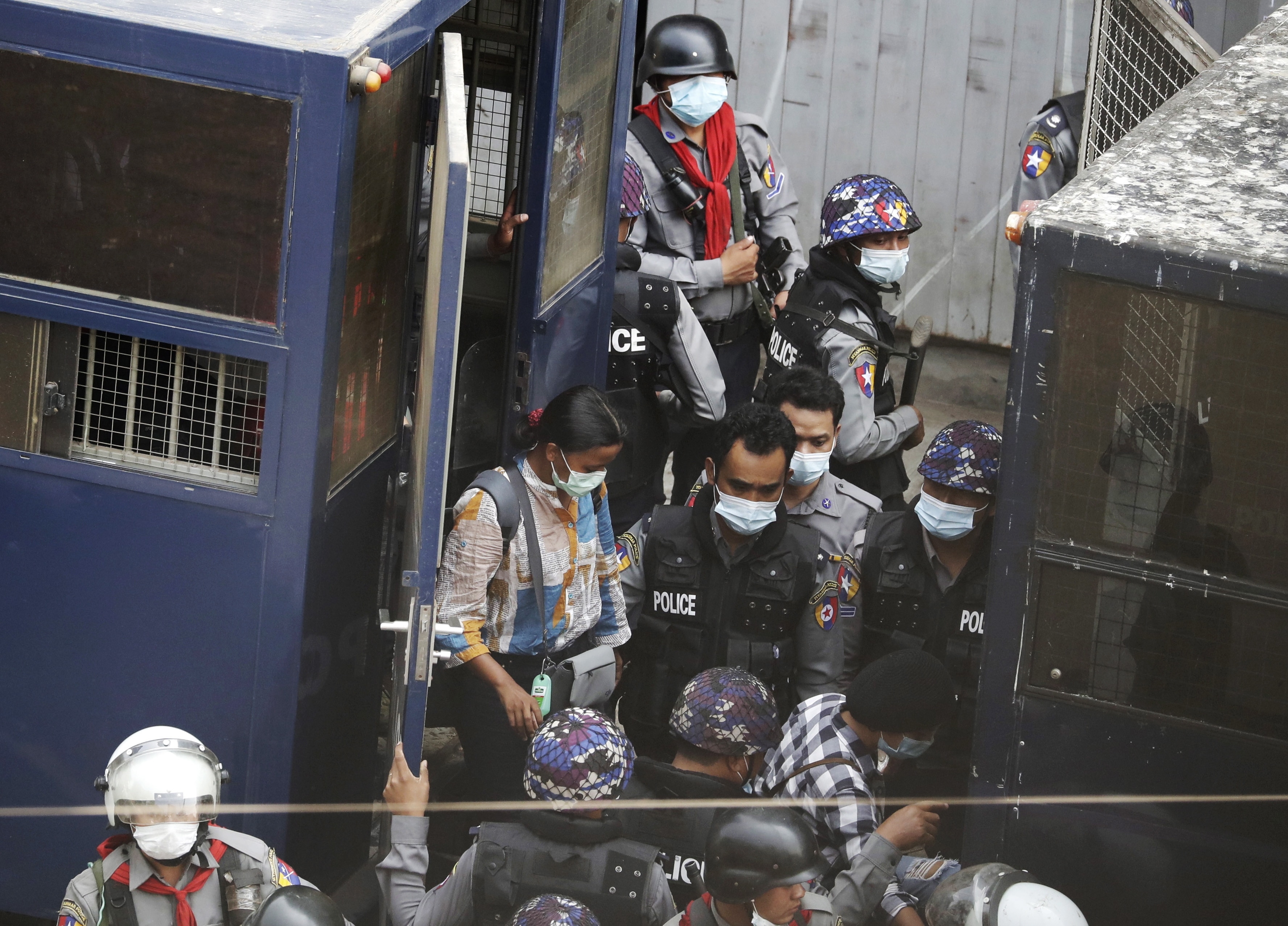 Police transfer arrested Myanmar journalist Kay Zun Nway from a police vehicle to another during a protest against the military coup in Yangon.