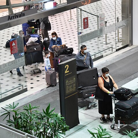 Australians evacuated from South America due to the coronavirus arrive at Brisbane International Airport on 14 April.