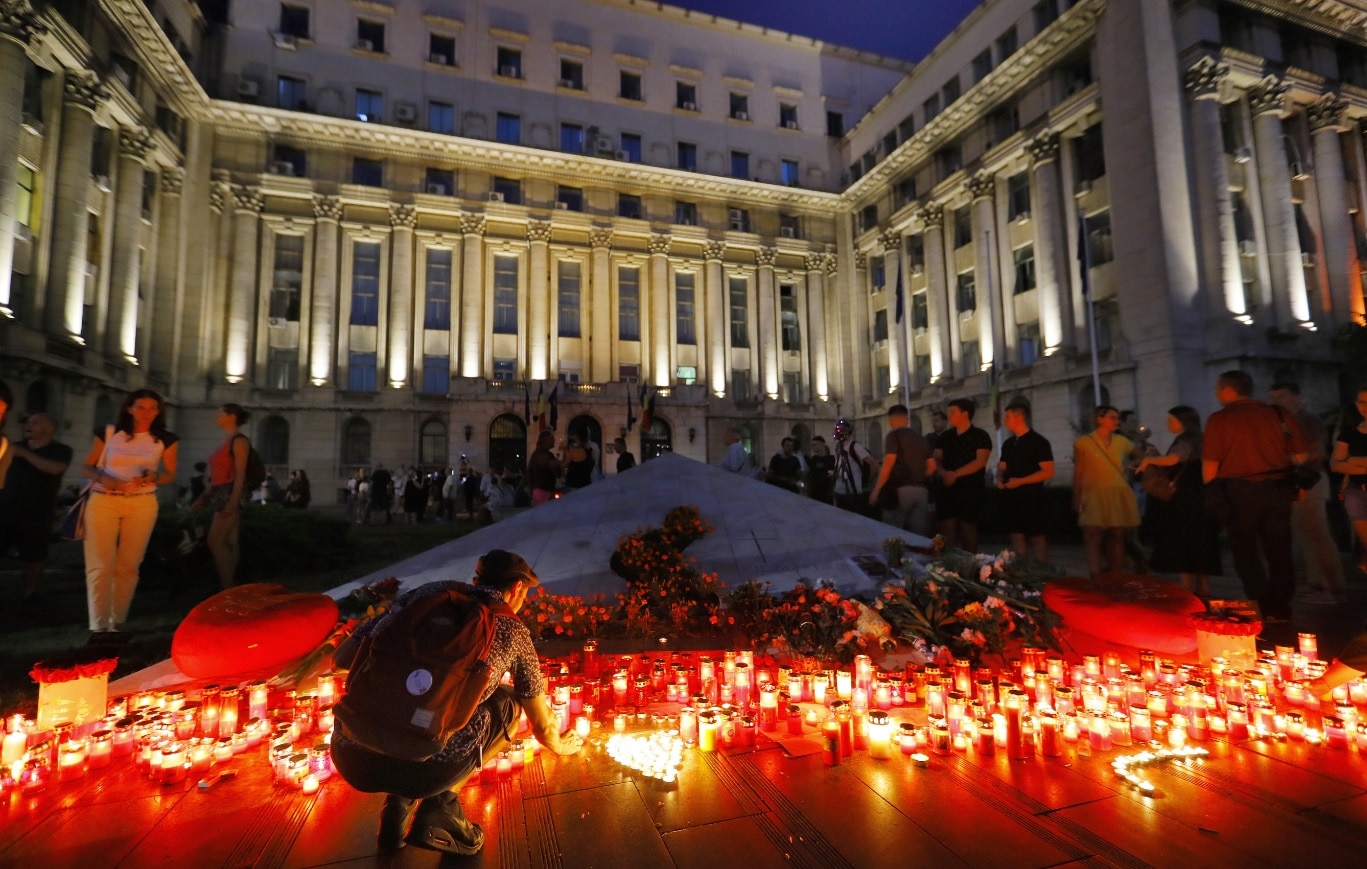 A Romanian young man kneels to light a candle at the end of a protest against the way Romanian authorities handled the kidnapping of a 15-years old girl A Romanian young man kneels to light a candle at the end of a protest against the way Romanian authorities handled the kidnapping of a 15-years old girl