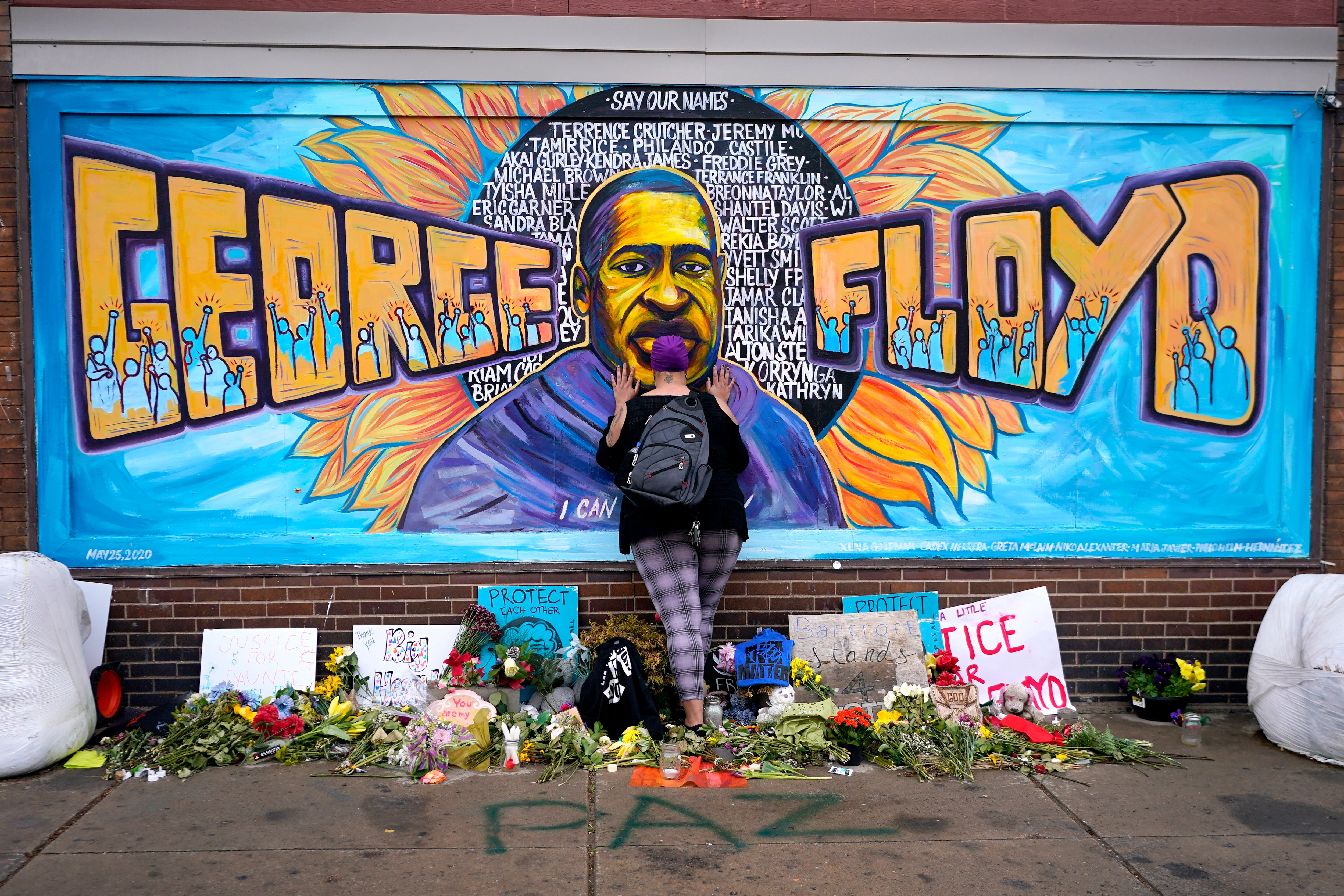 Une femme rend hommage à George Floyd lors d'une peinture murale à George Floyd Square, le 23 avril 2021, à Minneapolis.