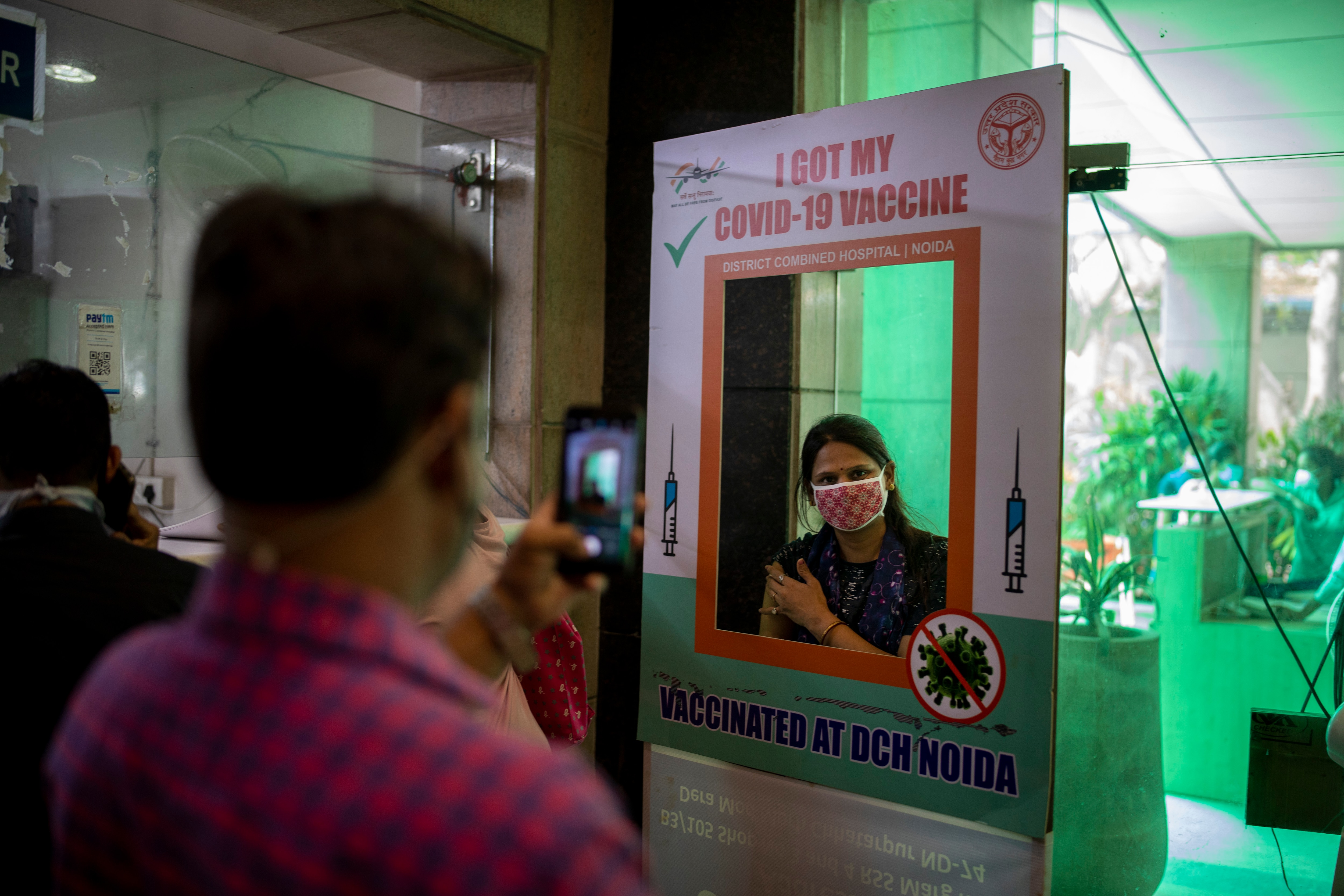 A woman poses behind a cutout after receiving a Covishield vaccine in India.