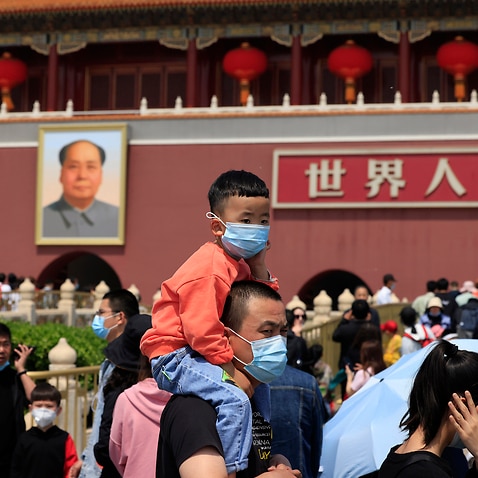 A man and child visit Tiananmen Gate near the portrait of Mao Zedong in Beijing on Monday, 3 May, 2021.