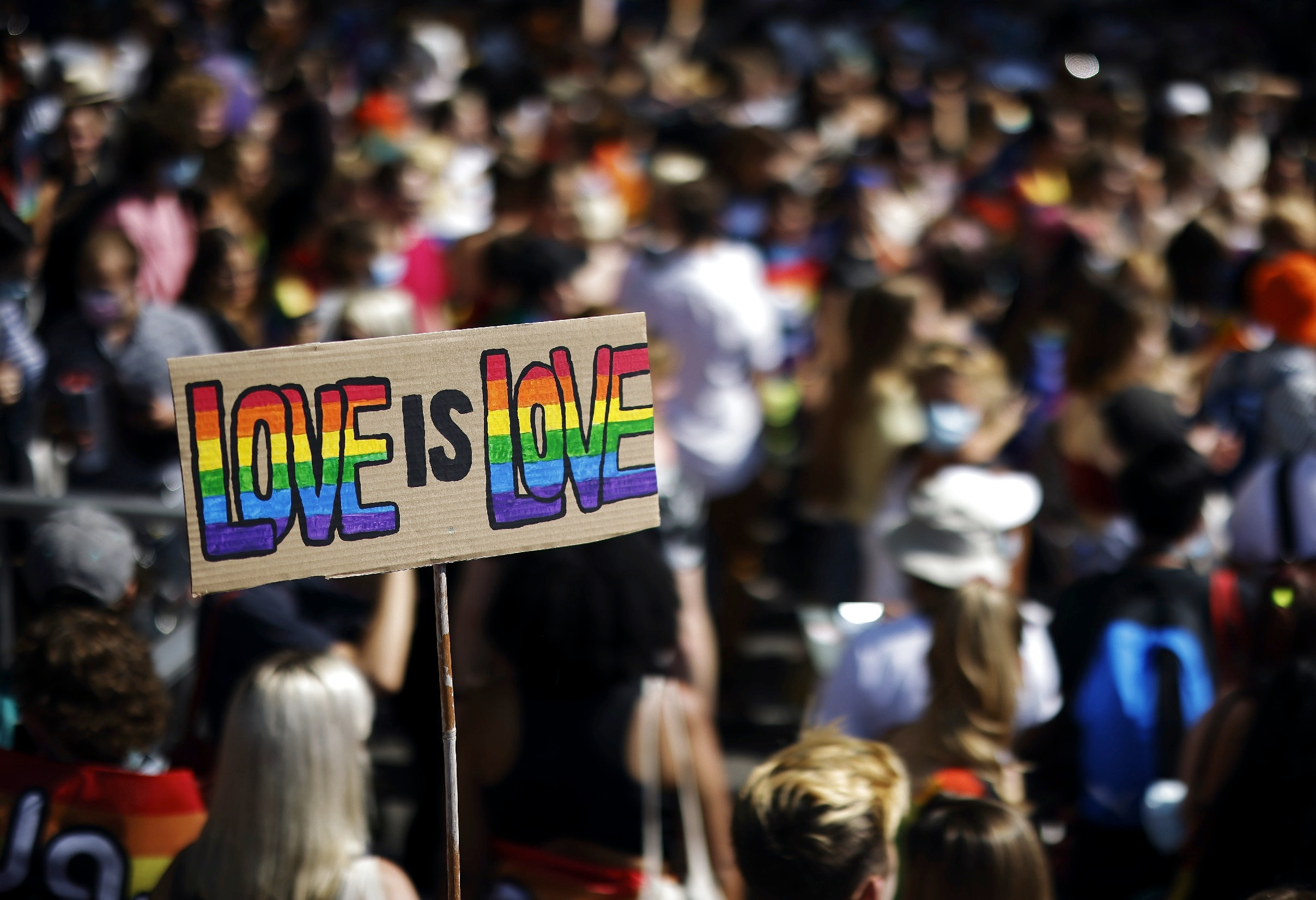 A person carries a placard that reads 'love is love' during a demonstration at the Zurich Pride parade.