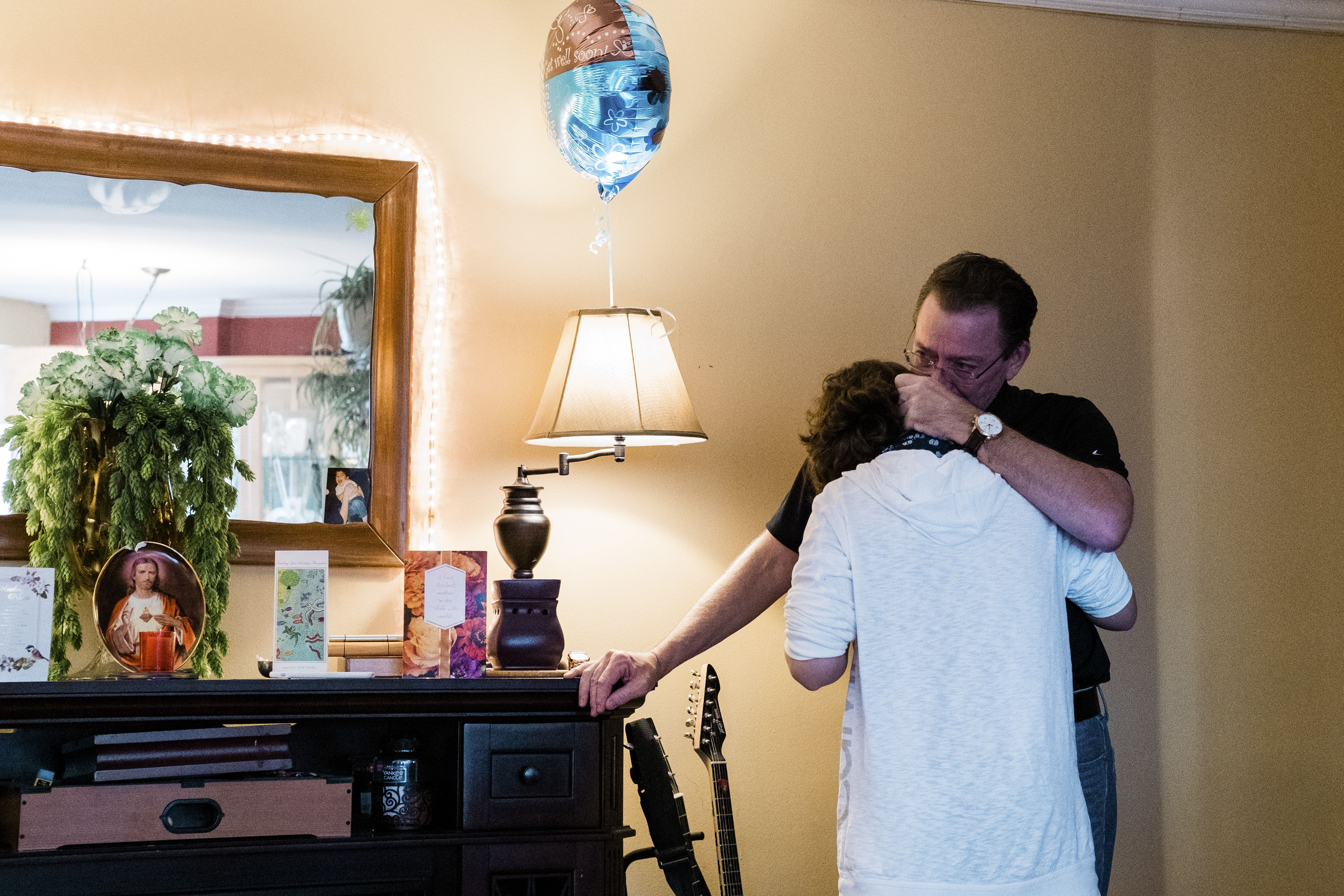 After his father, John McMorrow, choked on telling of his son's illness, Jack McMorrow kissed him in Queens, May 11, 2020. (Gabriela Bhaskar / The New York Times) 