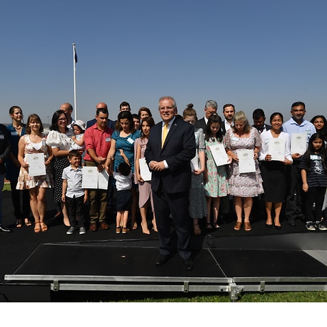 Prime Minister Scott Morrison poses for photos with new citizens during an Australia Day Citizenship Ceremony in Canberra.