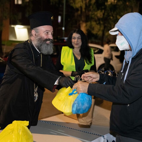 Archbishop Makarios handing out parcel in food relief initiative 