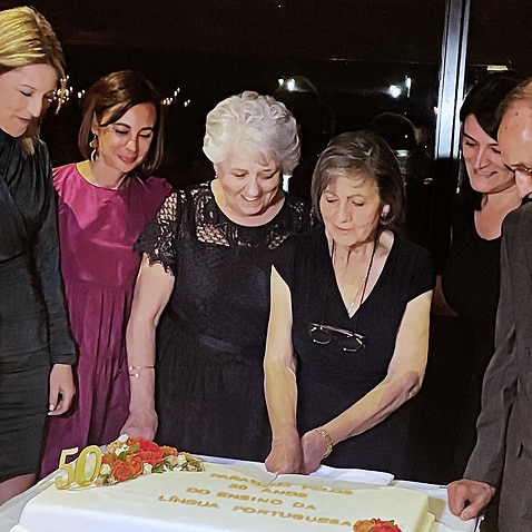 Cidália Rendeiro, ao centro a cortar o bolo comemorativo dos 50 anos da escola de Petersham/Marrickville, rodeada do seu grupo de professores, todos eles de parabéns.