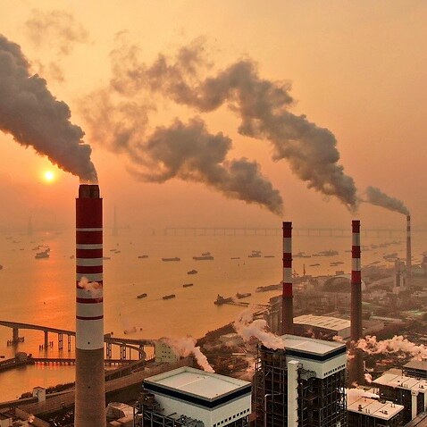 The sun sets near a coal-fired power plant on the Yangtze River in Nantong in eastern China's Jiangsu province on 12 December 2018.  