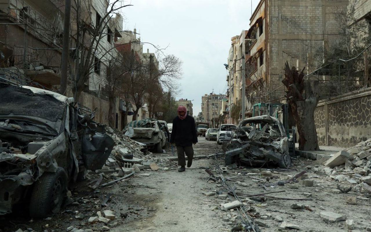 A Syrian man walking next to damaged buildings following regime air strikes in the Syrian rebel-held town of Douma, in the besieged Eastern Ghouta region.