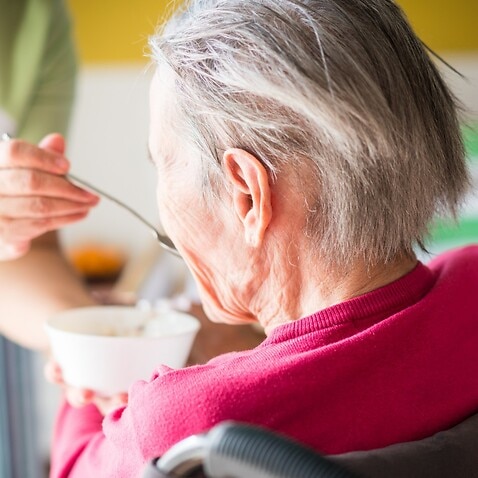 Elderly woman being fed 