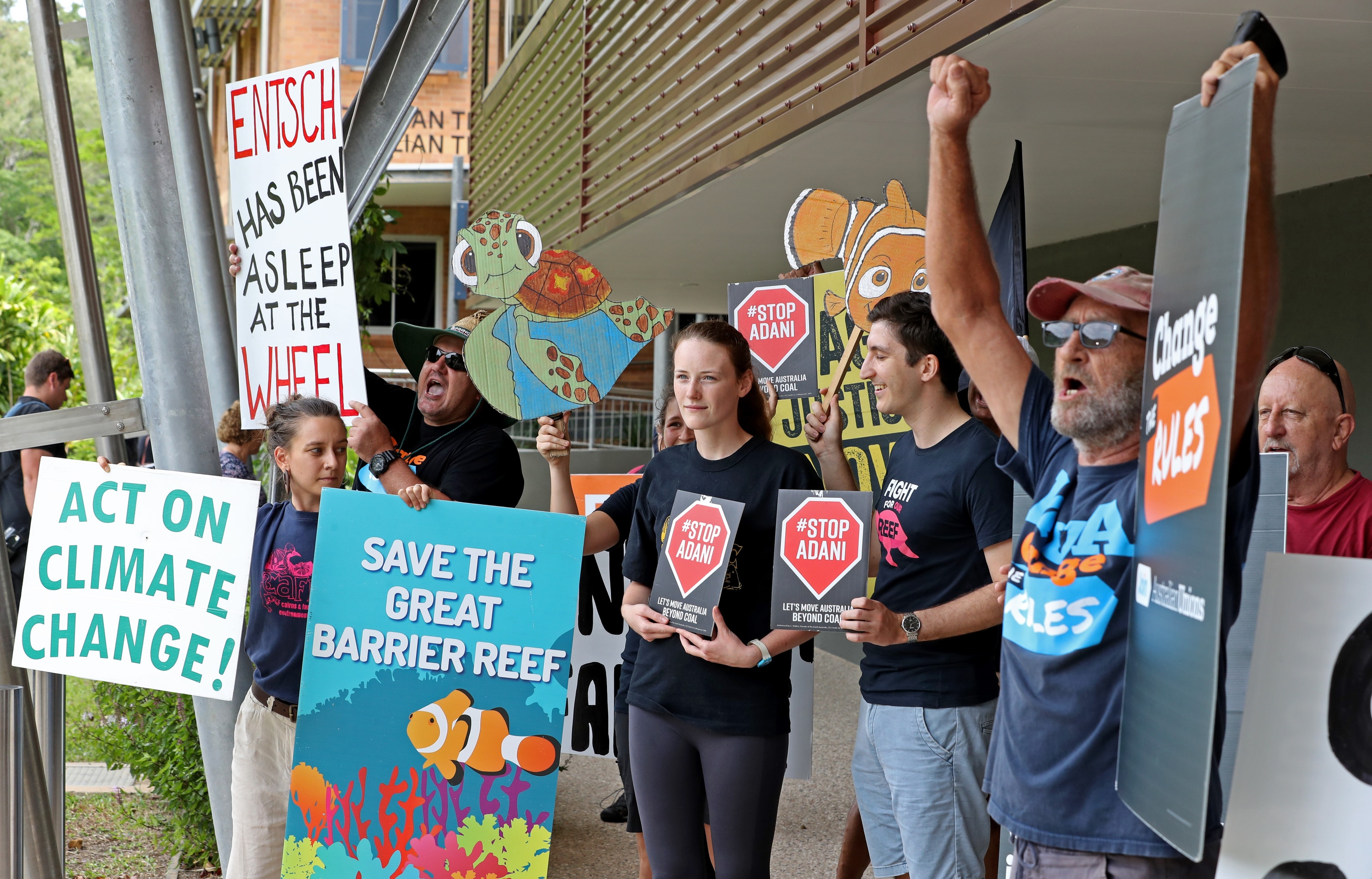 A small group of protesters greets Australian Prime Minister Scott Morrison and Warren Entsch MP during a visit to the Australian Institute of Tropical Health.
