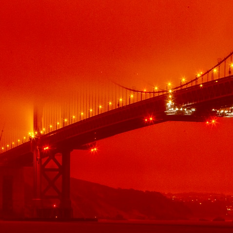 In this photo provided by Frederic Larson, the Golden Gate Bridge is seen at 11 a.m. PT amid a smoky, orange hue caused by the ongoing wildfires, Wednesday, Sept. 9, 2020, in San Francisco. (Frederic Larson via AP)