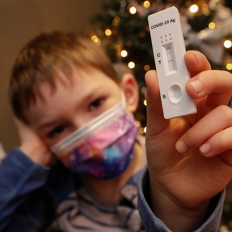 A Child poses with a positive rapid Covid-19 Antigen test