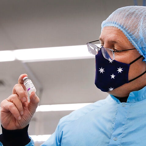 Prime Minister Scott Morrison holds a vial of AstraZeneca vaccine during a visit to the CSL serum lab to inspect COVID-19 Immunoglobulin being produced in Parkville, Melbourne, Friday February 12, 2021.