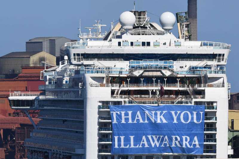 A 'Thank You Illawarra' sign hangs from the stern of the Ruby Princess cruise ship as it departs Port Kembla. 