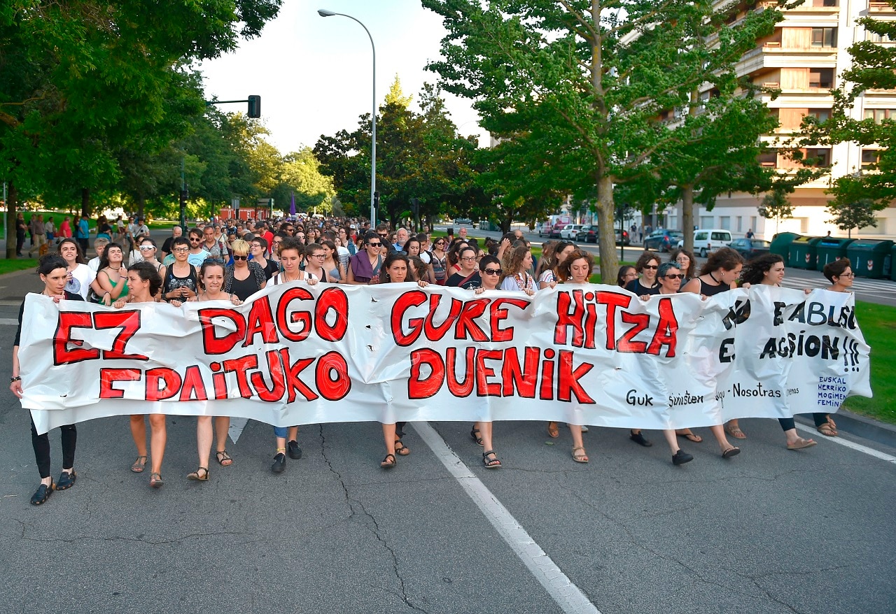 Protesters hold a banner reading "There is no one who judges our word - It is not abuse, it is aggression" in Pamplona.
