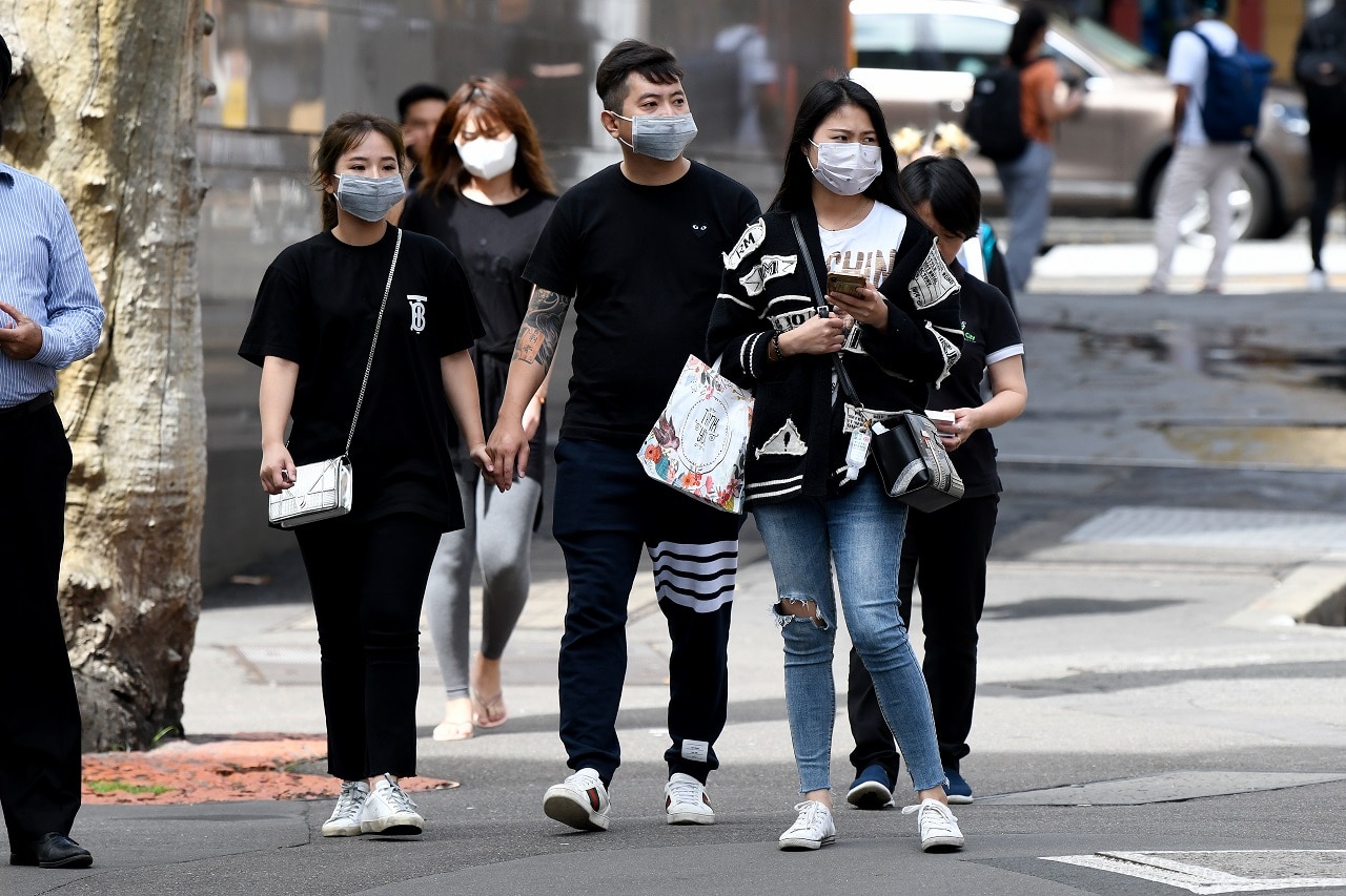 People wear face masks in Sydney on Monday.