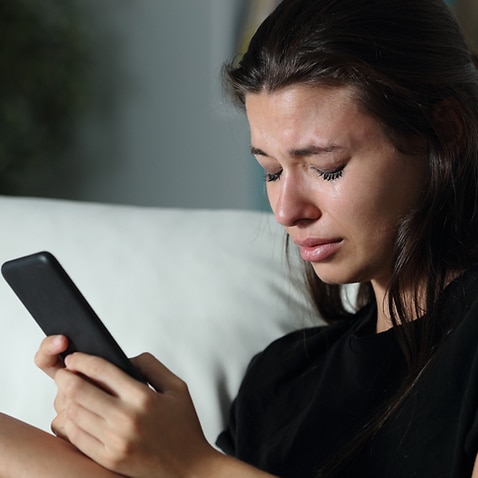 Sad teen crying after read phone message