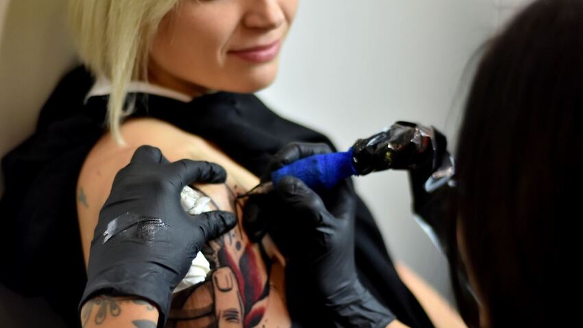 A woman being tattooed.