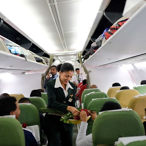 Passengers are welcomed by cabin crew inside an Ethiopian Airlines flight who departed from the Bole International Airport in Addis Ababa, Ethiopia, to Eritrea's capital Asmara on July 18, 2018.