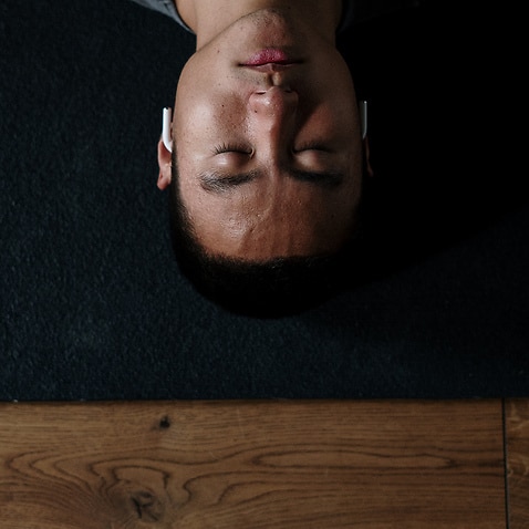 Man lying down with eyes closed, meditating