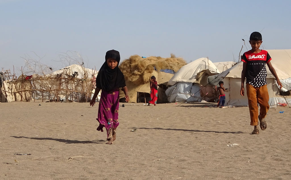 Children walk past tents at a displaced persons camp in the Khokha district of Yemen's western province of Hodeida.