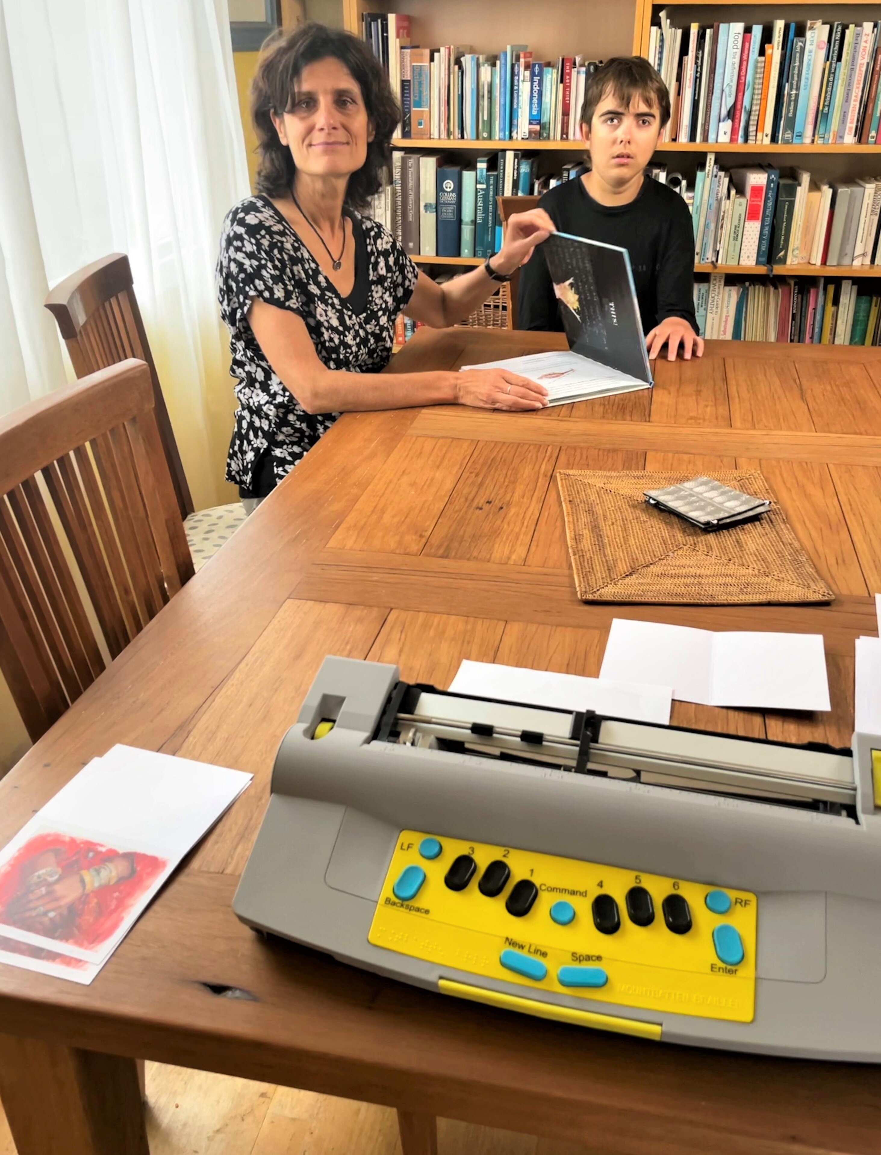 Luca reading a braille book with his mother Susanna.