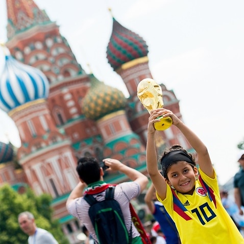 A fan holds up a replica World Cup Trophy on a visit to Red square during the FIFA World Cup in Moscow, Russia, 18 June 2018. 