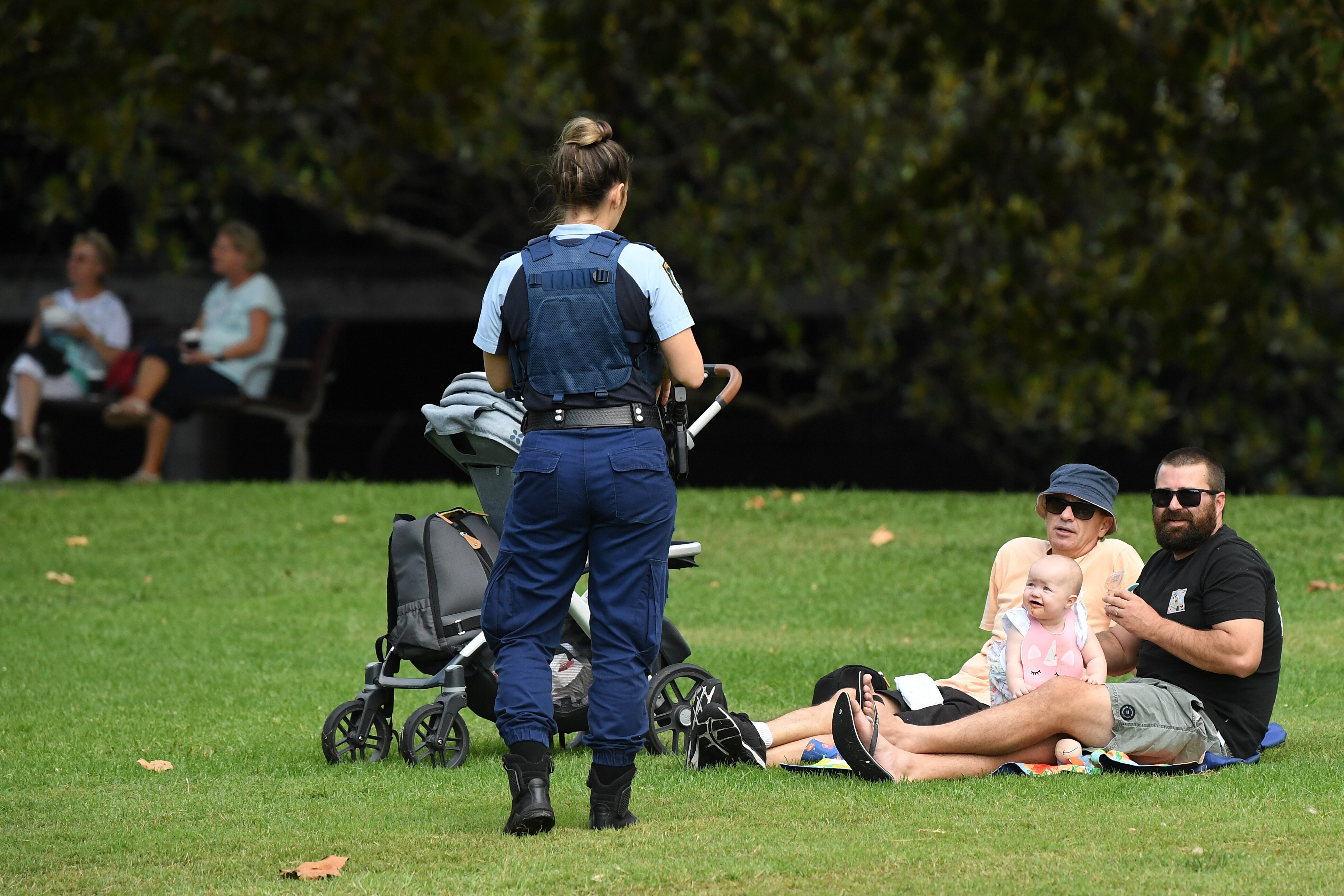 NSW Police officers ask a family to move on while on patrol at Rushcutters Bay park in Sydney.
