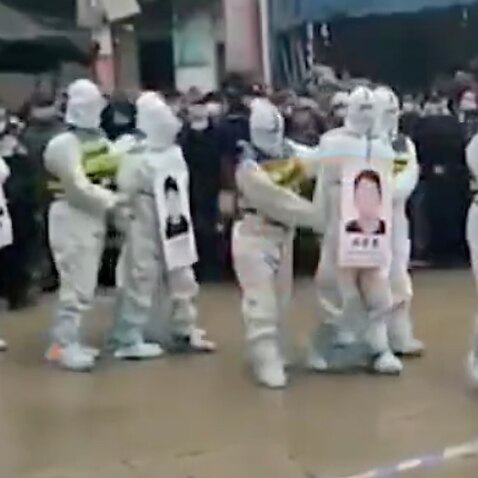 Four suspects in hazmat suits were reportedly paraded Tuesday in front of a large crowd in Guangxi region.