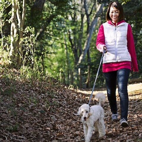 A woman is walking with her dog