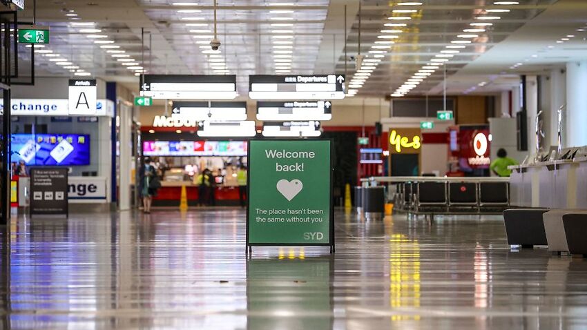 A sign is displayed inside the empty arrivals hall at the international airport in Sydney on 15 October, 2021.