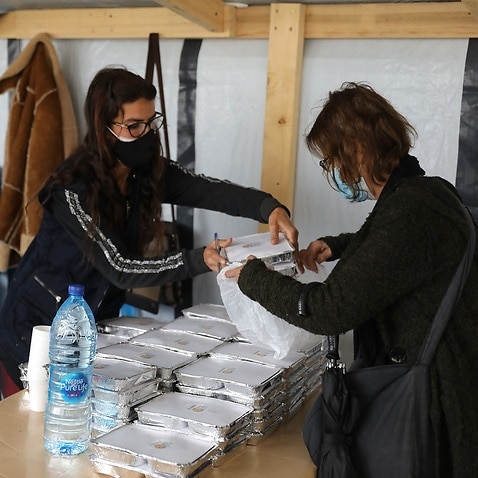 A volunteer gives food handouts to people in need in Beirut 