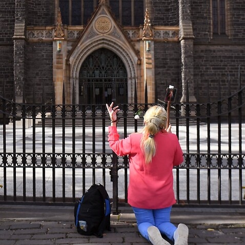 A woman prays outside St Patrick's Catholic Cathedral in Melbourne.