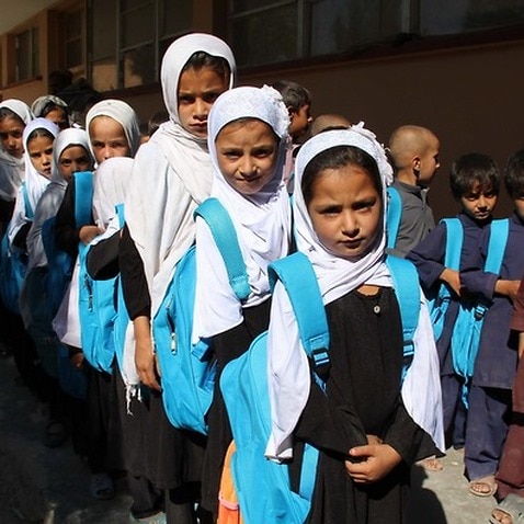 Afghan school children receive school bags and books distributed by the UNICEF in Helmand, Afghanistan