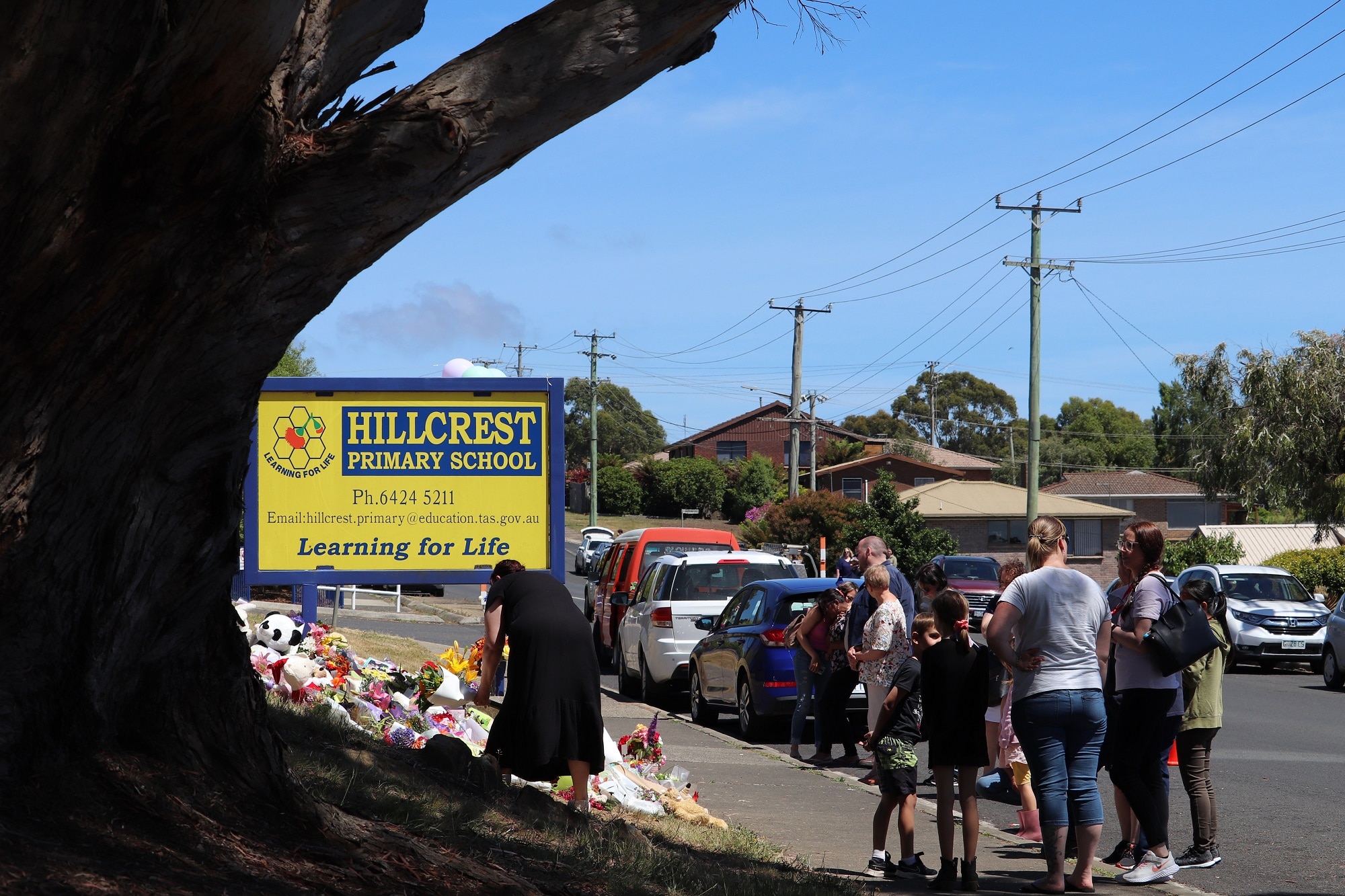 Members of the local community in Devonport console each other as they grieve the death of five children. 