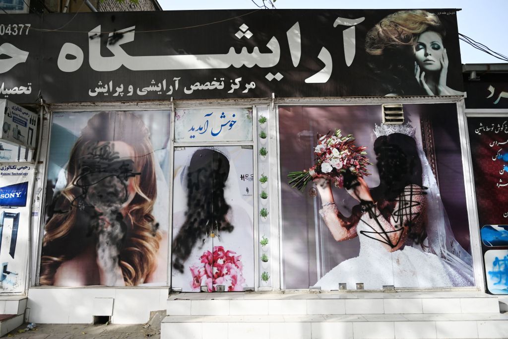 The facade of a beauty salon is pictured with images of women defaced using spray paint in Kabul on August 18, 2021.