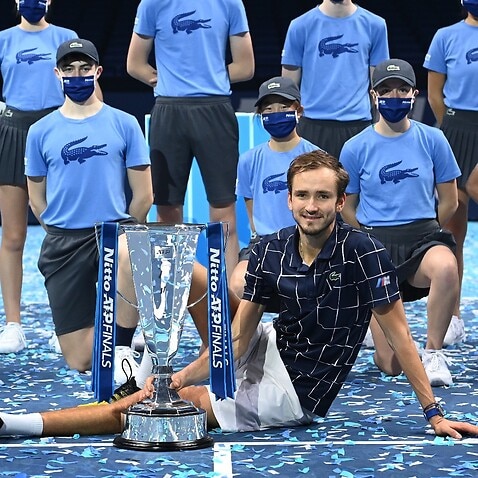 Daniil Medvedev of Russia poses with his trophy and ball boys after winning against Dominic Thiem of Austria their final match at the ATP World Tour Finals tennis tournament in London, Britain, 22 November 2020. 