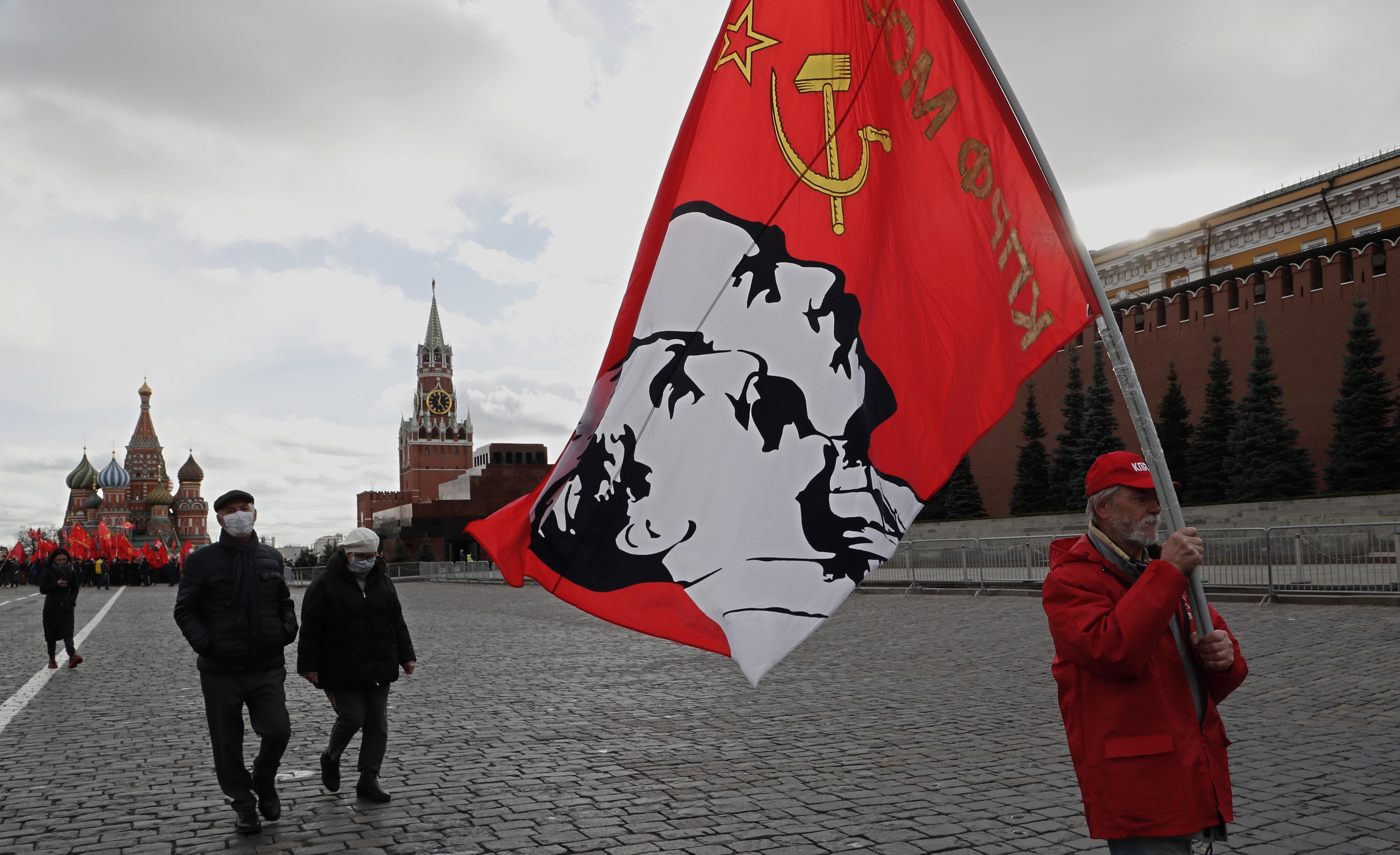 Piazza Rossa di Mosca - Un nostalgico del partito comunista con una bandiera che ritrae due dei simboli dell'URSS, Lenin e Stalin