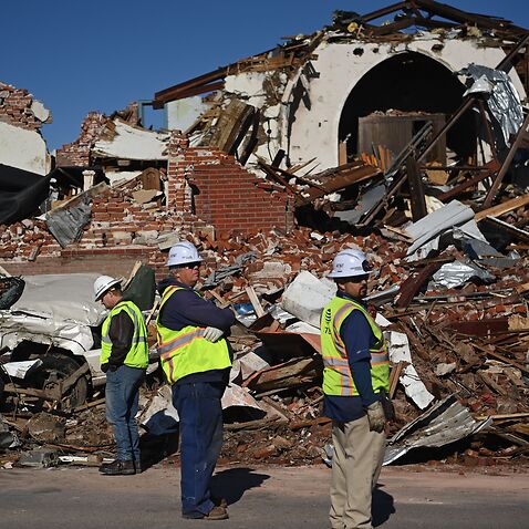 Workers survey tornado damage after extreme weather hit the region on 12 December 12.