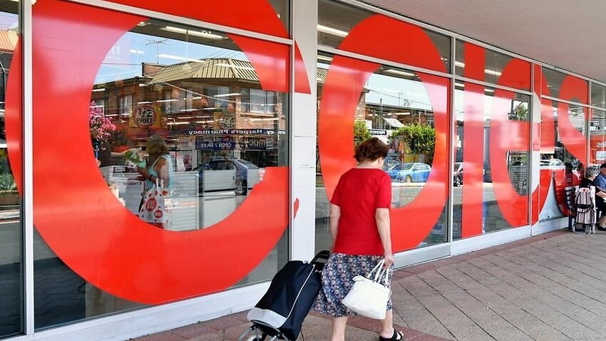 A shopper walks past a Coles supermarket in Sydney