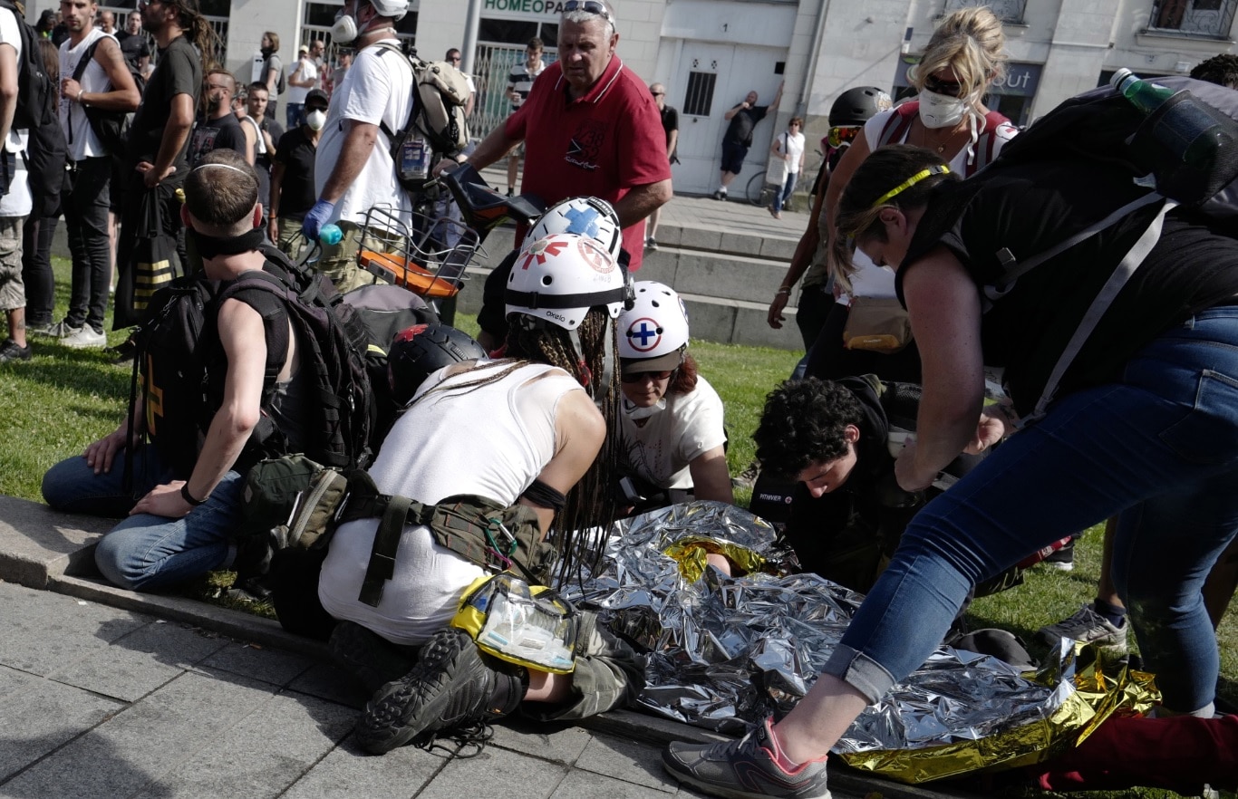 Street medics give assistance to a person before being evacuated to hospital by firefighters. Street medics give assistance to a person before being evacuated to hospital by firefighters.