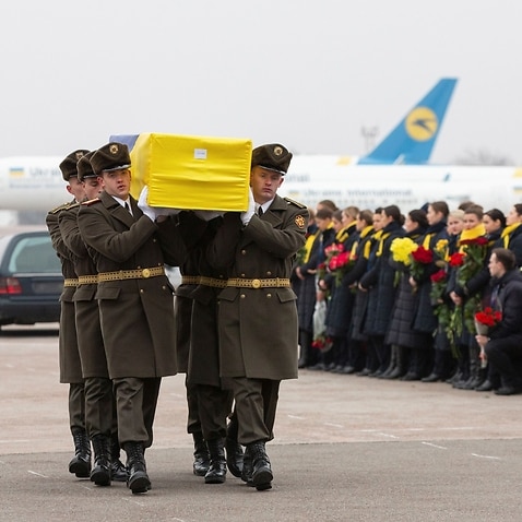 An honour guard carries a coffin of the one of the Ukrainian victims of the plane that crashed in Iran 