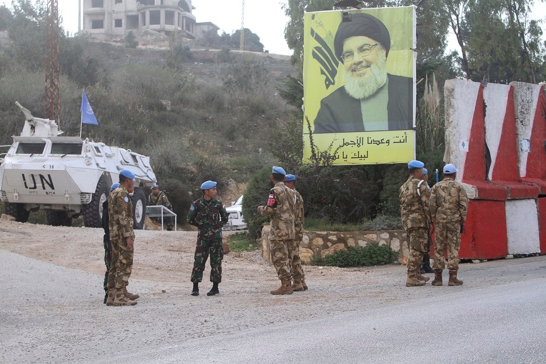 Indonesian UN peacekeepers stand in front a poster of Hezbollah leader Sheik Hassan Nasrallah, as they patrol the Lebanese side of the  border. 
