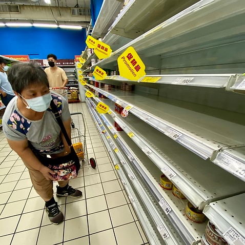 A woman checks an almost empty shelf as residents rushed to buy grocery essentials inside a supermarket in Taipei, Taiwan, 17 May 2021. 