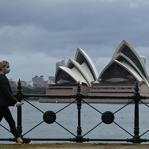 A pedestrian walks past the Sydney Opera House in Sydney, Saturday, 10 July, 2021. 