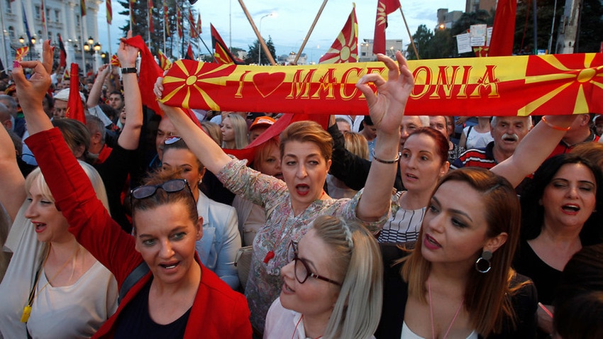 People chant during a protest over the proposed change, in front of the Government building in Skopje, Macedonia.