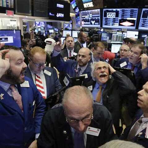 Specialist Charles Boeddinghaus, left, directs trading at his post on the floor of the New York Stock Exchange, Wednesday, Nov. 9, 2016. 