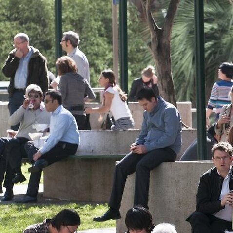 Office workers sit in the sun at lunchtime in Brisbane, Wednesday, Aug. 1, 2012.  (AAP Image/John Pryke) NO ARCHIVING
